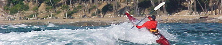 Kayaker navigating waves at shoreline